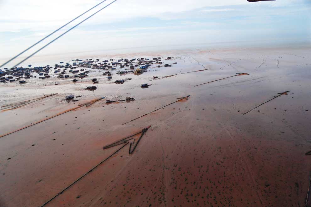An aerial view of the Chong Kneas floating village and a number of traditional arrowhead-style fish traps exposed by record low water levels on the Tonle Sap Lake in Siem Reap province last year. Over 80,000 people live directly on the lake, and experts say their livelihoods are at risk. Alessandro Marazzi Sassoon