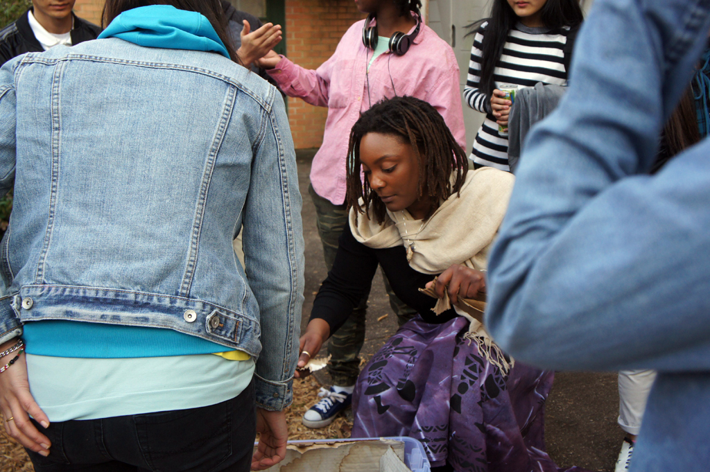 FoodCorps service member Zashe Cockett-Demings helps students at Clarkston High School in Clarkston, Georgia, make a worm composting bed for the after-school Garden Club. FoodCorps is part of AmericCorps.
