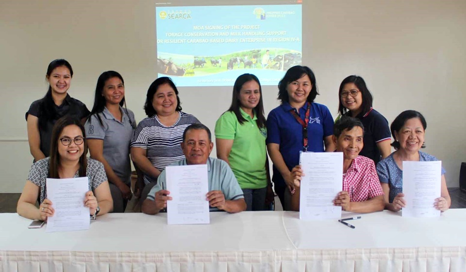 Board Members of RODRA and GENTRI, together with PCC and SEARCA Officials and Staff, posed for a photo with the signed MOA for the project, Forage Conservation and Milk-Handling Support for Resilient Carabao-Based Dairy Enterprise in Region IV-A, on 13 February 2018 at SEARCA Residence Hotel.