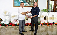 Dr. Dyball as he hands the book, Understanding Human Ecology, to Dr. Saguiguit.