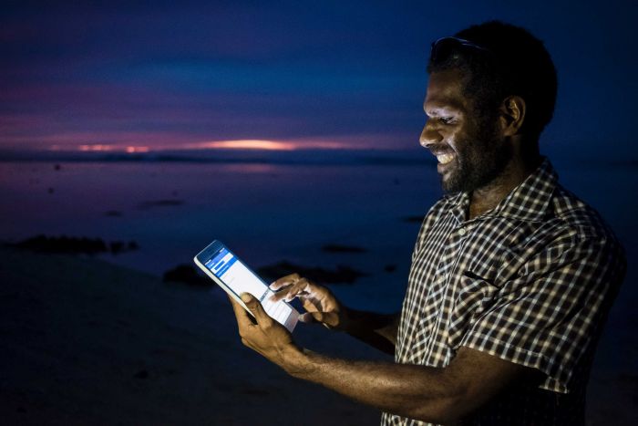 Social researcher Jeromy Kavi uses a tablet to conduct baseline research in Papua New Guinea. (Supplied: Conor Ashleigh/ACIAR)