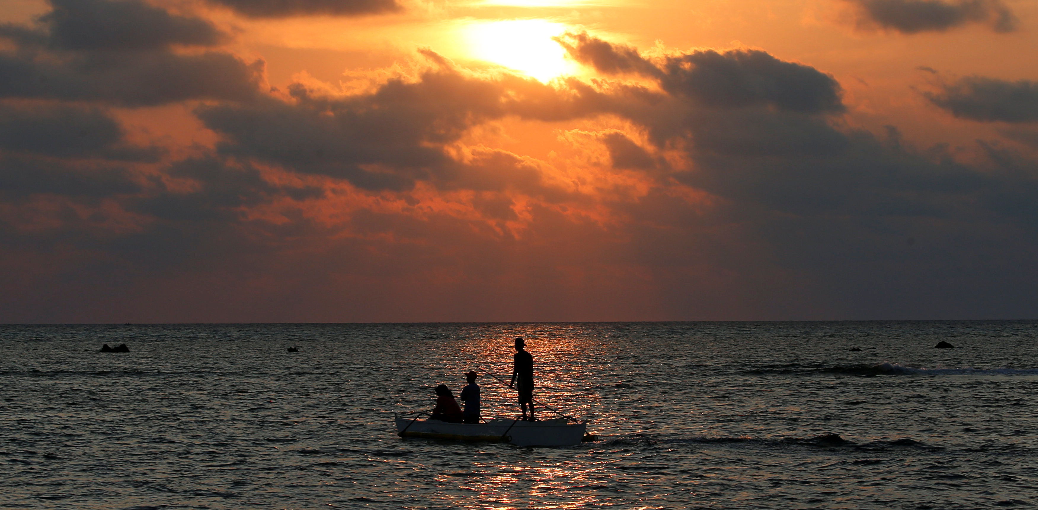 Philippine fishermen steer a dinghy during sunset in the disputed Scarborough Shoal. Photo: Reuters/Erik De Castro