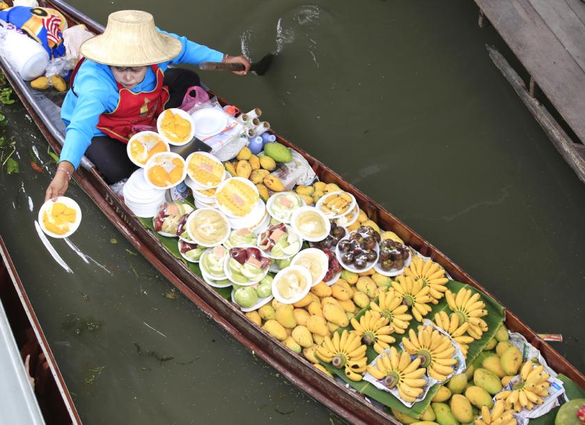 A woman offers fresh fruit for sale to tourists at Damnoen Saduak floating market in Ratchaburi province, Thailand, in 2015. Photo - EPA