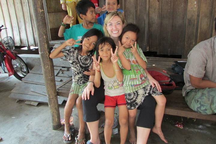 Dr. Kyly Whitfield poses with children in this photo taken during her previous work in rural Cambodia.