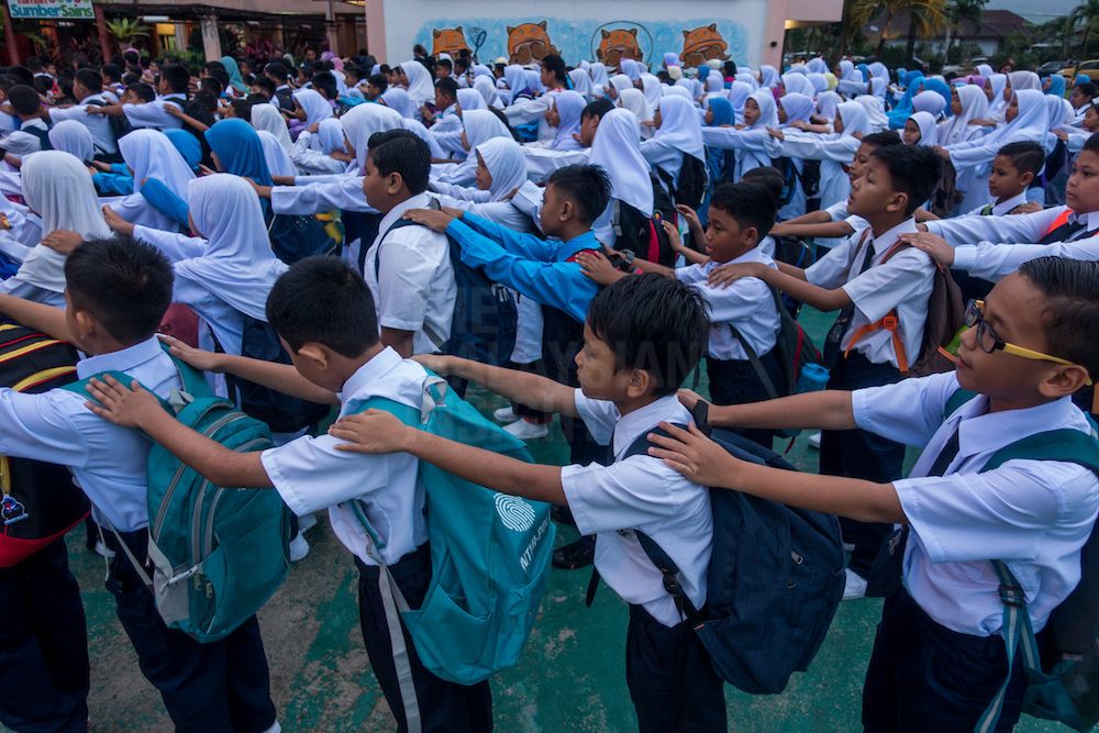 Pupils line up before class. New rules by the Education and Health Ministries prohibits 13 food items high in fat and salt content from being sold at school canteens. – The Malaysian Insight file pic, January 31, 2018.