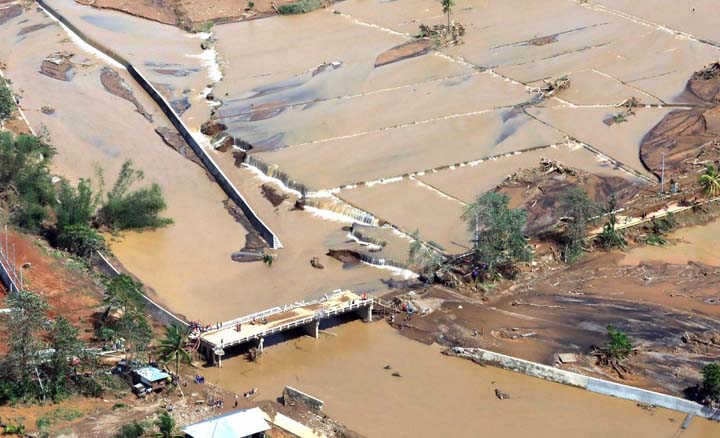 Residents stand on the damaged Caraycaray Bridge after Tropical Storm Urduja hit the island province of Biliran on December 18, 2017