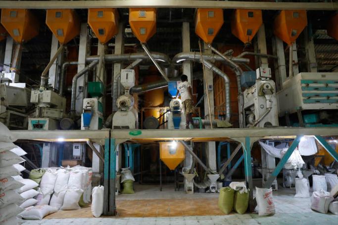 Myanmar man works at a rice mill in Moulmeingyun township of Ayeyarwaddy region, Myanmar. Photo: Lynn Bo Bo/EPA