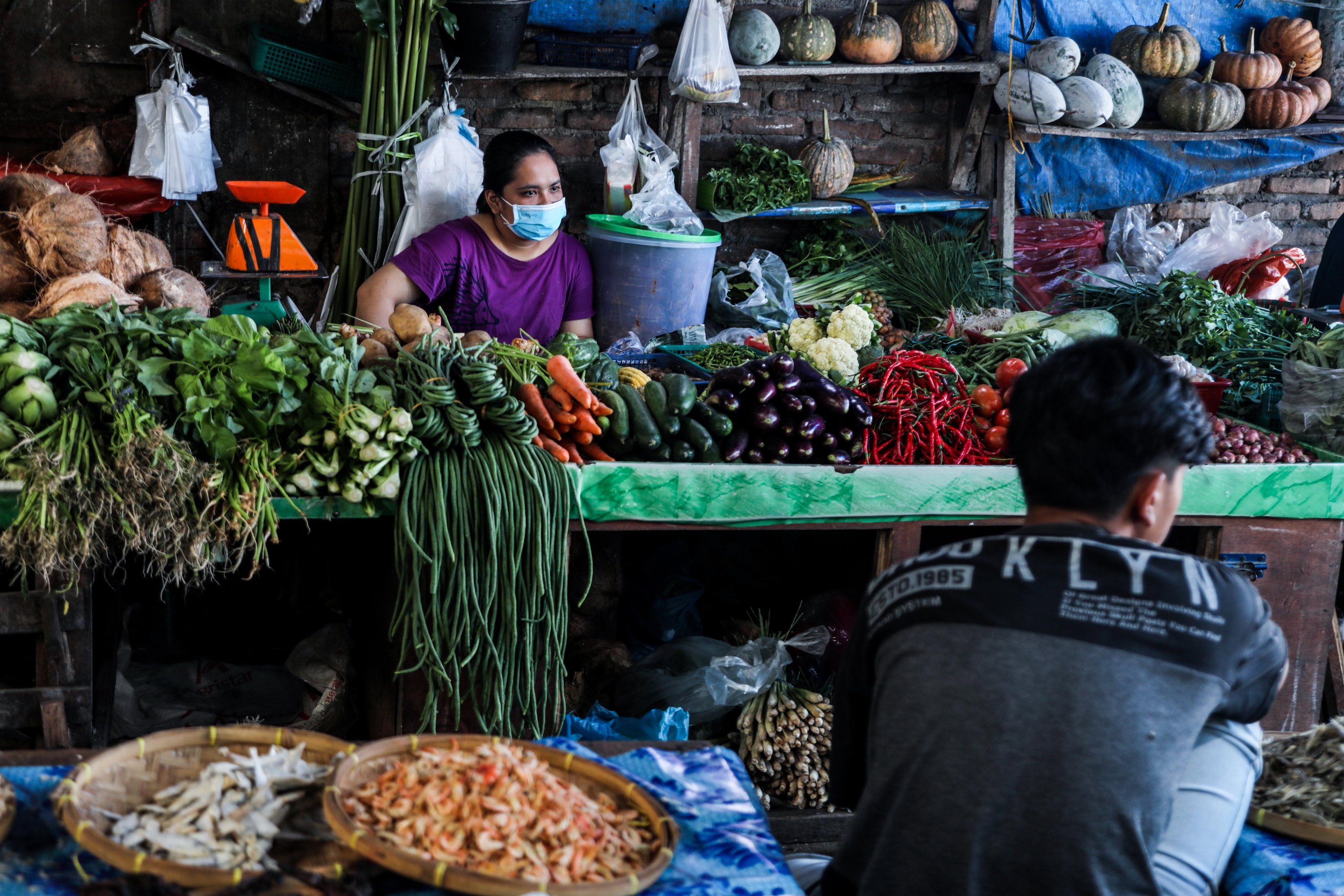 Vegetable vendors wait for customers at a market in Medan, North Sumatra, Indonesia, Feb 2, 2021 (Photo: AFP)
