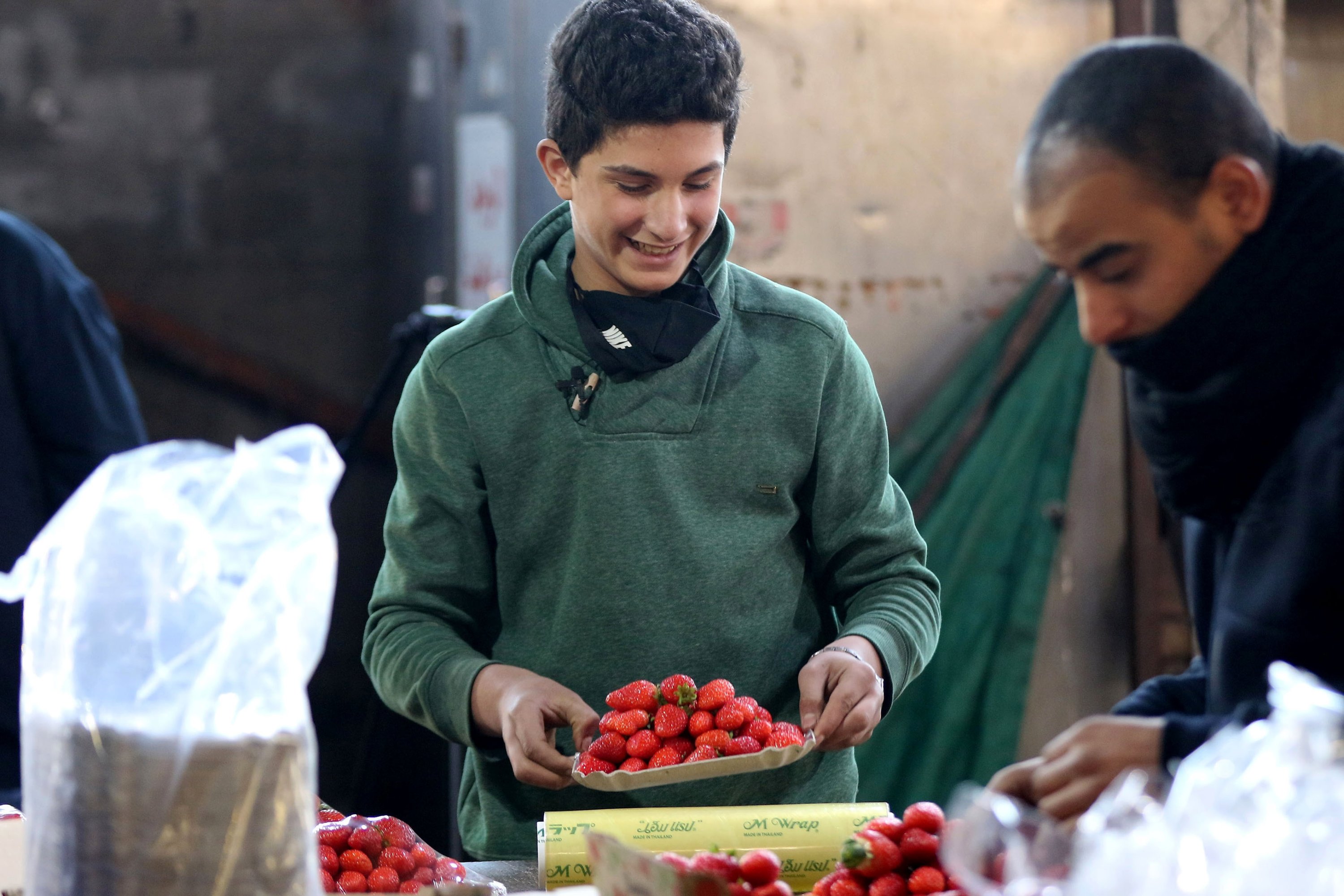 Mohammad, 14, arrange strawberry boxes in one of Amman’s popular vegetable and fruit markets, Jordan, Jan 10, 2021. (Photo: AFP)