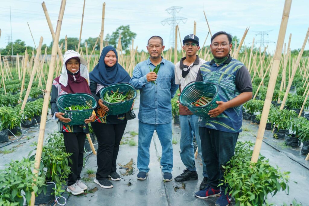 Hj Arine (C) with the AgroZid team in Sg Liang. Hj Arine has also employed several AgroBiz graduates under his farming company,